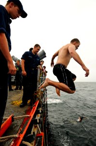 US Navy 110920-N-YM590-344 Gas Turbine Systems Technician (Electrical) Fireman Apprentice William Anderson jumps from the fantail of USS Anzio (CG