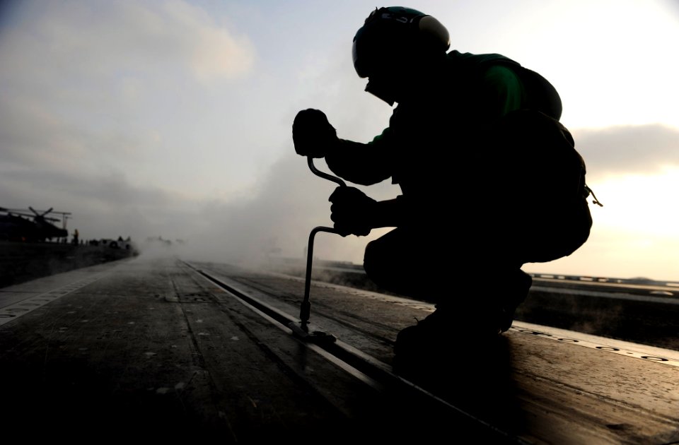 US Navy 110918-N-ZZ999-540 Aviation Boatswain's Mate 3rd Class Alfred Ranili, from Cebu, Philippines, removes buttons from catapult three before fl
