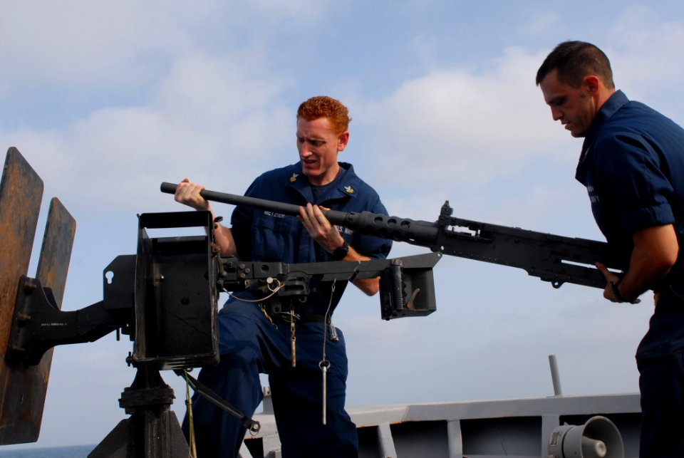 US Navy 110919-N-DU438-119 Fire Controlman 1st Class Byran Metzger, left, and Gunner's Mate 1st Class Merle Albright mount a .50-caliber machine gu