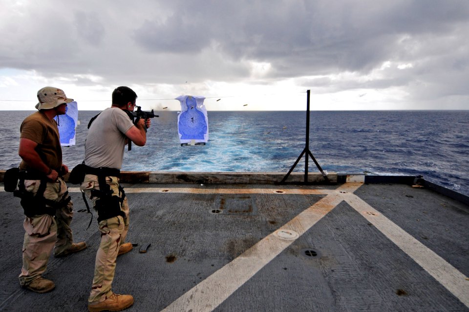 US Navy 110919-N-RC734-606 Boatswain's Mate 3rd Class Justin Sims fires an M4 rifle during a small arms live-fire exercise on the flight deck aboar