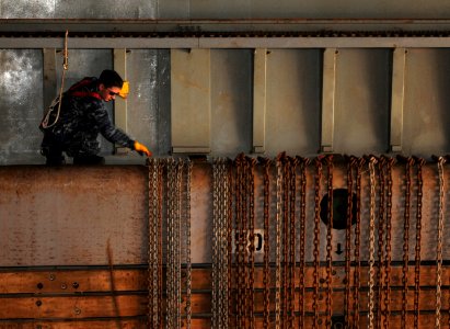 US Navy 110921-N-MW330-244 Electronics Technician 3rd Class Eli Cashman, from Sanford, Fla., releases chains from their stowed position above the w