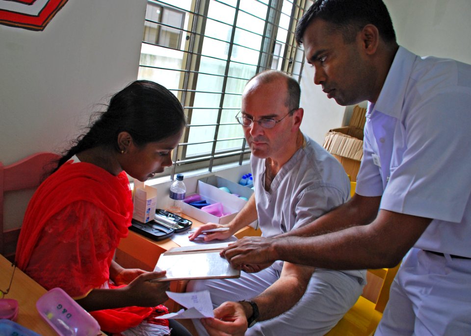 US Navy 110922-N-VP123-166 Capt. Mike Radouic, center, a Navy optometrist, and a Bangladesh navy technician administer an eye test at a medical civ