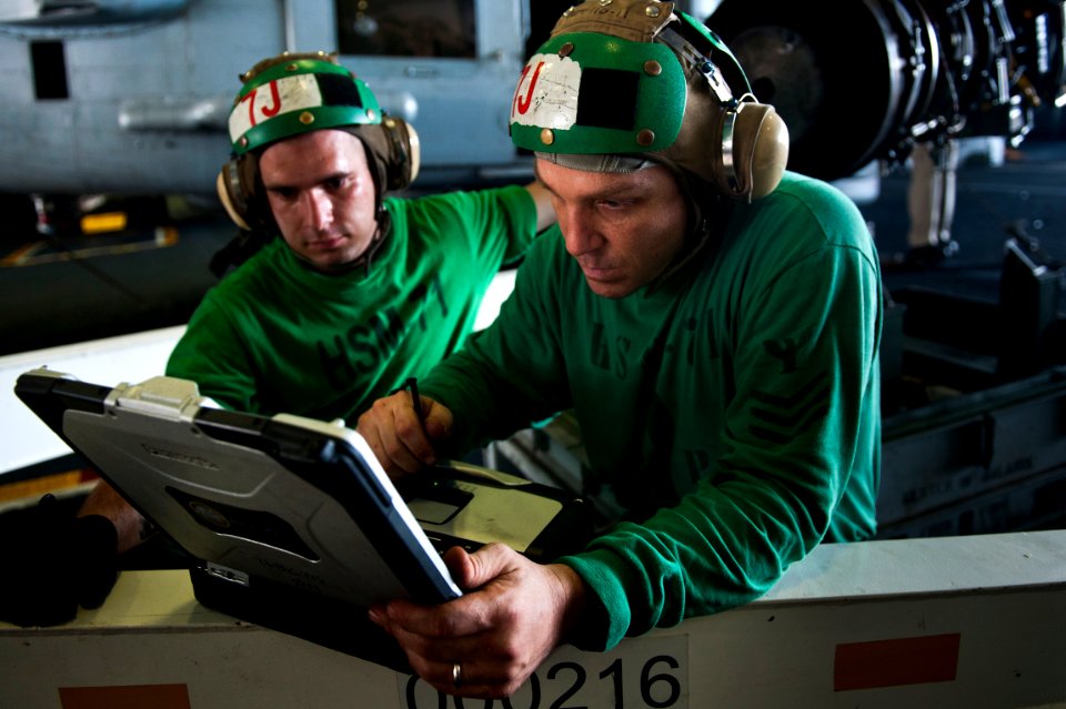 US Navy 110919-N-BT887-455 Aviation Machinist's Mate 1st Class Marcus Campagna, from Huntington Beach, Calif., refers to schematics before installi