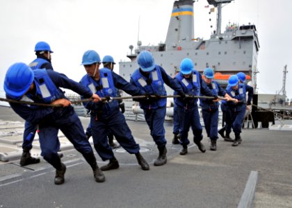 US Navy 110922-N-ZF681-286 Sailors aboard the guided-missile destroyer USS Halsey (DDG 97) heave a fuel line from the Military Sealift Command flee