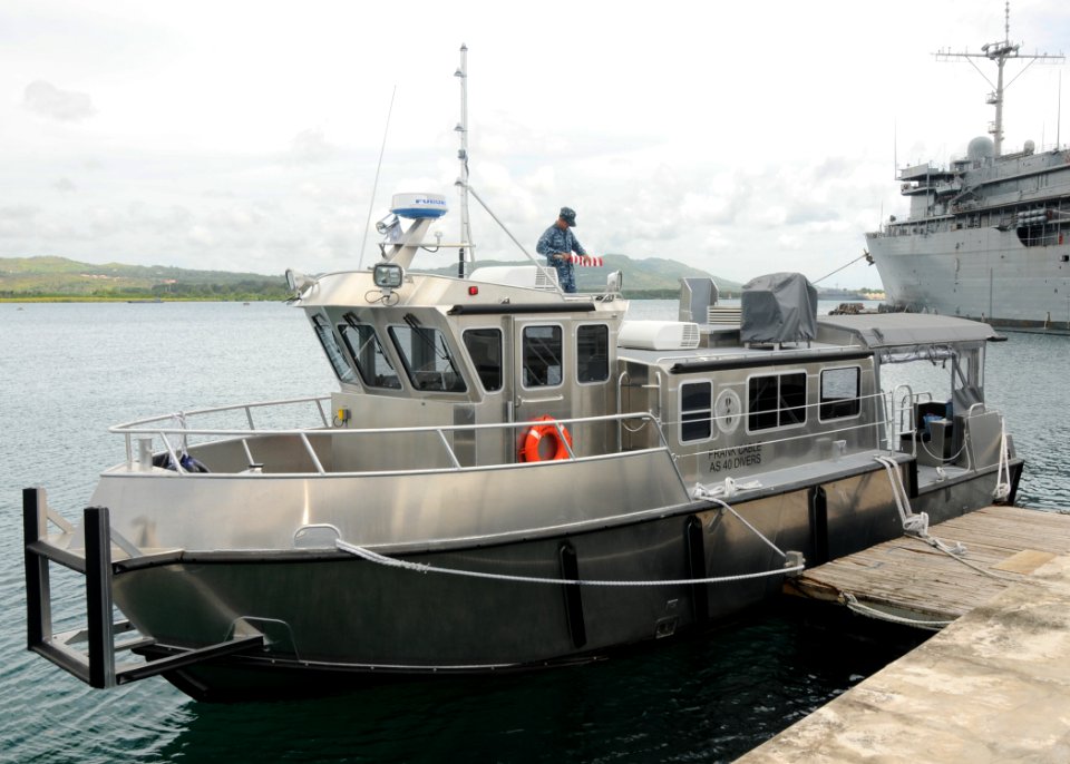 US Navy 110919-N-JB593-063 Seaman Recruit John Steinhauer rolls up the national ensign on the dive vessel after securing from a test run