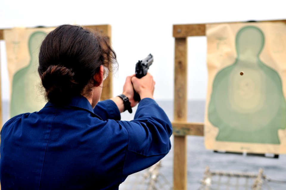 US Navy 110919-N-ZF681-107 Ensign Jennifer Rubin fires a 9mm handgun during small arms qualifications aboard the guided-missile destroyer USS Halse