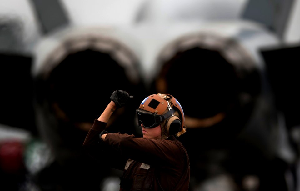 US Navy 110923-N-TU221-336 A plane captain signals a pilot during a pre-flight inspection aboard the Nimitz-class aircraft carrier USS Abraham Linc