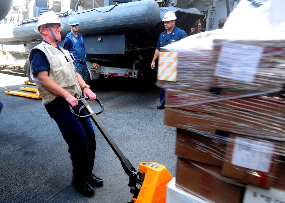 US Navy 110922-N-CT127-119 Command Master Chief Ryan Wagner pulls a pallet of stores aboard the San Antonio-class amphibious transport dock ship US