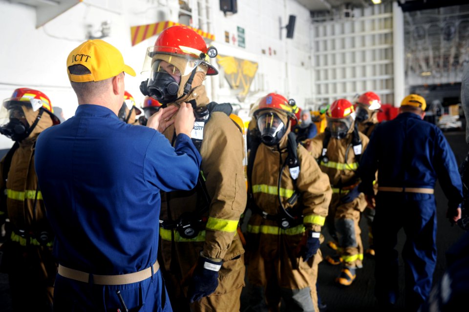 US Navy 110923-N-AU622-023 Mass Communication Specialist 3rd Class Erick Kogler has his firefighting equipment checked by the damage control team d