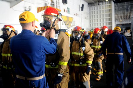US Navy 110923-N-AU622-023 Mass Communication Specialist 3rd Class Erick Kogler has his firefighting equipment checked by the damage control team d
