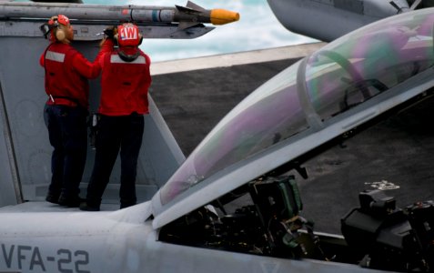 US Navy 110922-N-OK922-173 Sailors assigned to Strike Fighter Squadron (VFA) 22 load a missile on an F-A-18F Super Hornet aboard Nimitz-class aircr