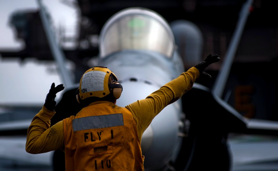US Navy 110922-N-TU221-497 An aircraft director guides an F-A-18C Hornet assigned to Strike Fighter Squadron (VFA) 34 on the flight deck of the Nim