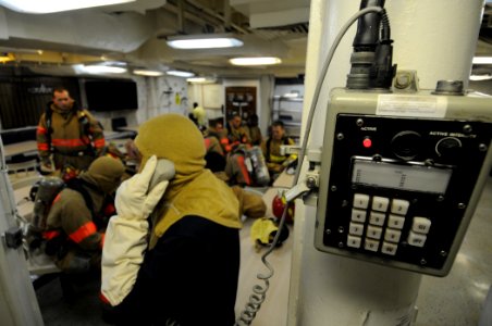 US Navy 110920-N-XQ375-013 Logistics Specialist 2nd Class Nelson Felix communicates with a repair locker using an integrated voice communication sy