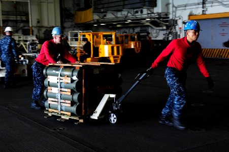 US Navy 110922-N-WA347-043 Aviation Ordnanceman 3rd Class Larry Ildefonso, right, and Aviation Ordnanceman 2nd Class Peter Phipps move a pallet of