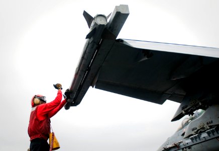 US Navy 110923-N-TZ605-405 An aviation ordnanceman assigned to Strike Fighter Squadron (VFA) 22 secures ordnance on an F-A-18F Super Hornet aboard