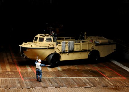US Navy 110921-N-MW330-117 Boatswain's Mate 1st Class Kencey Welly guides a logistical amphibious recovery craft (LARC)
