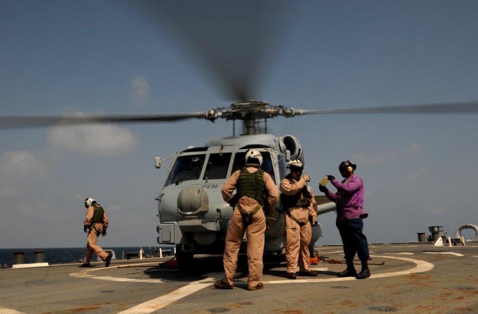 US Navy 110925-N-XQ375-047 Gas Turbine System Technician (Mechanical) 2nd Class Carrington Jones, right, shows a sample of JP-5 fuel to an MH-60R S
