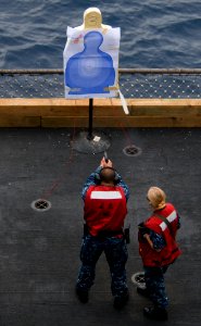 US Navy 110924-N-OK922-276 Gunner's Mate 2nd Class Ashley Jebens, assigned to Weapons Department's G-2 Division, instructs a Sailor during a 9mm pi