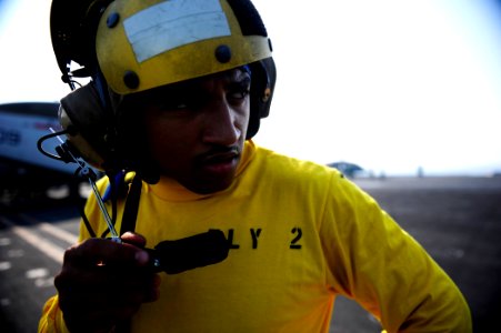 US Navy 110925-N-VN693-021 Aviation Boatswain's Mate (Handling) Airman Apprentice Terrance Wever, from Charleston, S.C., uses the microphone