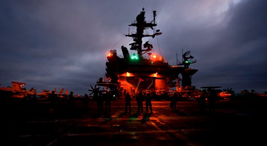 US Navy 110926-N-TU221-063 Sailors wait as an MH-60R Sea Hawk helicopter launches from the Nimitz-class aircraft carrier USS Abraham Lincoln (CVN 7