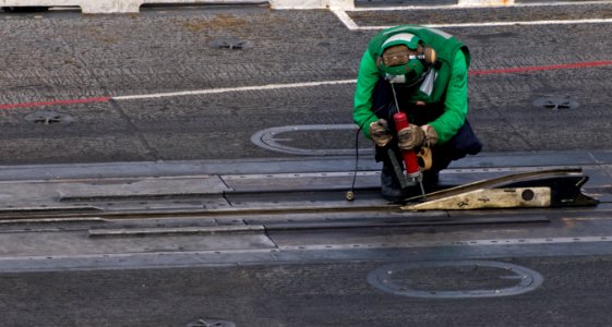 US Navy 110925-N-OK922-006 Aviation Boatswain's Mate (Equipment) 3rd Class Alex Cormier, assigned to Air Department's V-2 Division, performs mainte