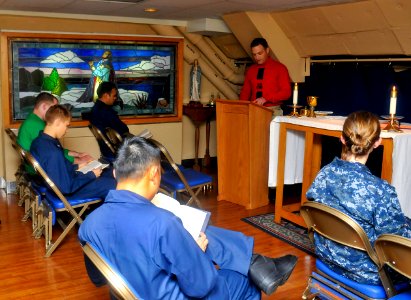 US Navy 110925-N-SF704-121 Chief Gunner's Mate Dustin Cooke, from Poughkeepsie, N.Y., reads a passage from the Bible during a Roman Catholic Mass a