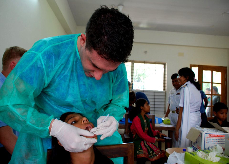 US Navy 110922-N-VP123-149 Hospital Corpsman 2nd Class Jared Meyers, assigned to Commander, Task Force 73, cleans a Bangladeshi girl's teeth at a m