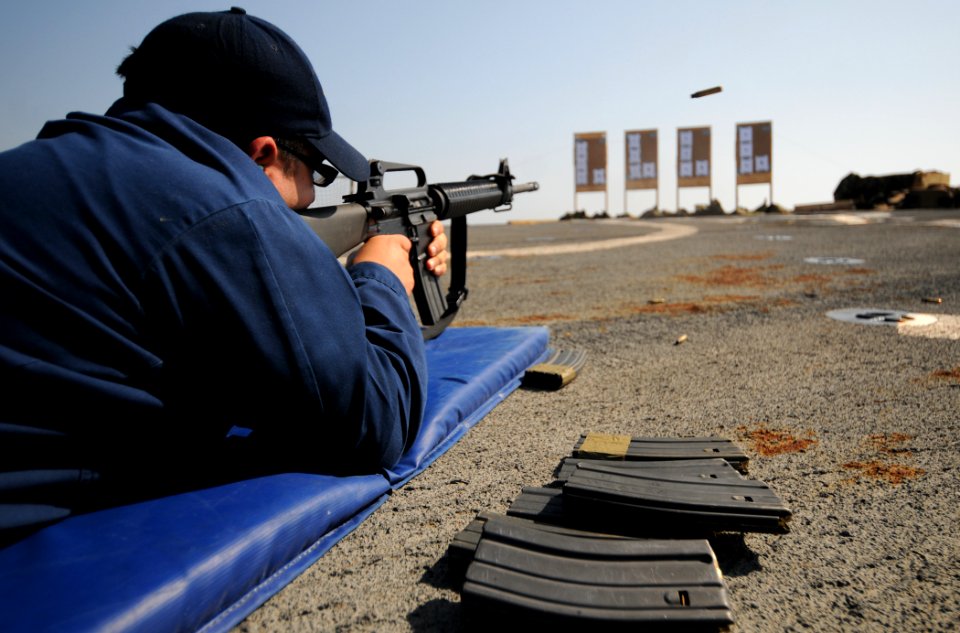 US Navy 110922-N-XQ375-237 Fire Controlman 2nd Class Angel Aceves fires an M16 rifle during a weapons qualification exercise on the flight deck of