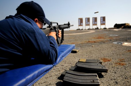 US Navy 110922-N-XQ375-237 Fire Controlman 2nd Class Angel Aceves fires an M16 rifle during a weapons qualification exercise on the flight deck of