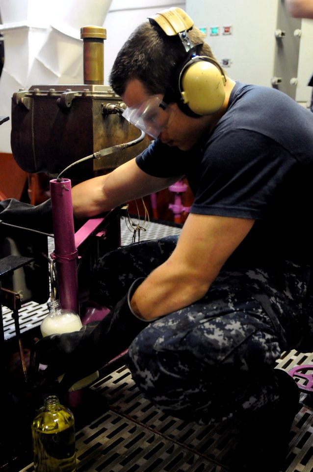 US Navy 110927-N-YC505-007 Aviation Boatswain's Mate (Fuel) Airman Cody L. Johnson takes a fuel sample to inspect for contaminants aboard the airc