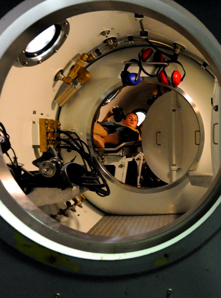 US Navy 110928-N-BA263-022 Navy Diver 2nd Class Daniel Grace role-plays as a patient during a recompression chamber supervisor drill