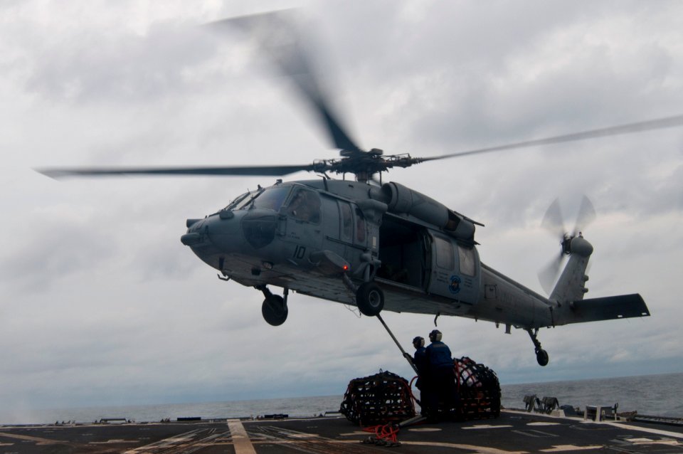 US Navy 110927-N-EA192-126 Sailors hook a pendant to an SH-60S Sea Hawk helicopter during a vertical replenishment at sea aboard USS Mustin (DDG 89