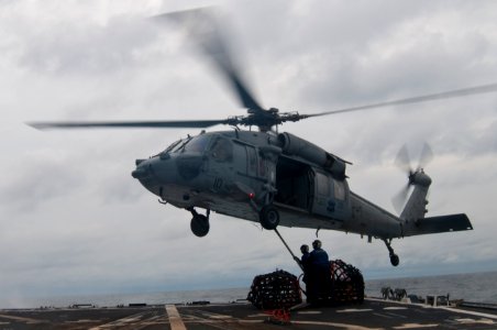 US Navy 110927-N-EA192-126 Sailors hook a pendant to an SH-60S Sea Hawk helicopter during a vertical replenishment at sea aboard USS Mustin (DDG 89