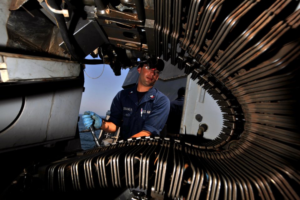 US Navy 110923-N-YZ751-020 Fire Controlman 2nd Class Christopher J. Matranga performs maintenance on a MK-38 25mm machine gun