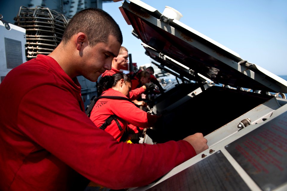 US Navy 110928-N-BT887-033 Aviation Machinist's Mate Airman Gonzalo Mendez cleans a jet locker containing ammunition aboard the Nimitz-class aircra