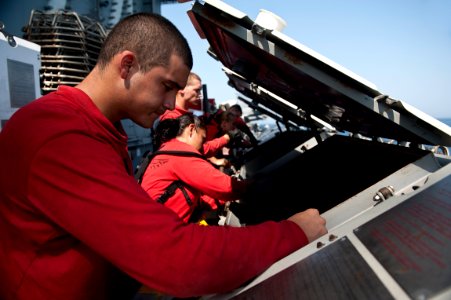 US Navy 110928-N-BT887-033 Aviation Machinist's Mate Airman Gonzalo Mendez cleans a jet locker containing ammunition aboard the Nimitz-class aircra
