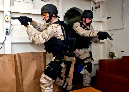 US Navy 110927-N-FI736-156 Fire Controlman 2nd Class Anthony Ferretti, left, and Fire Controlman 2nd Class Jody Powell clear a room during a visit