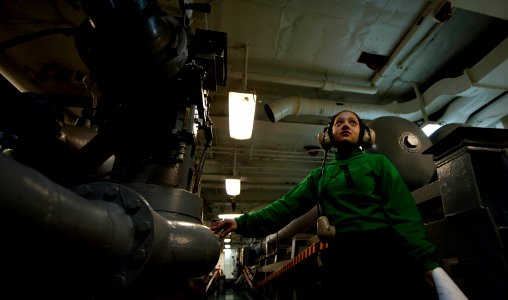 US Navy 110924-N-TU221-143 Aviation Boatswain's Mate (Equipment) Airman Gabrielle Dewitt stands watch inside an arresting gear machinery room photo