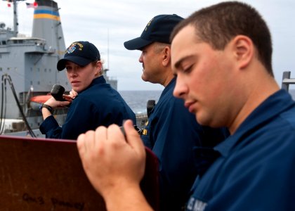 US Navy 110926-N-FI736-105 Ensign Selby Miller relays course and speed readings to Culinary Specialist Seaman Russell Goretsky aboard the guided-mi