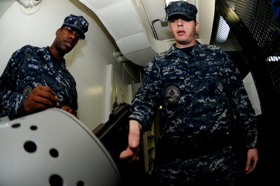 US Navy 110928-N-TU894-035 Aviation Boatswain's Mate (Fuel) Airman Clay V. Dailey, right, loads a 9mm pistol under the supervision of Cryptologic T