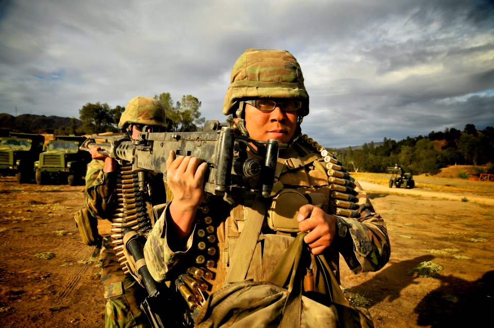 US Navy 110925-N-SM578-150 Utilitiesman 3rd Class Sze Yeung, a Seabee assigned to Naval Mobile Construction Battalion (NMCB)40, carries a 50-calibe