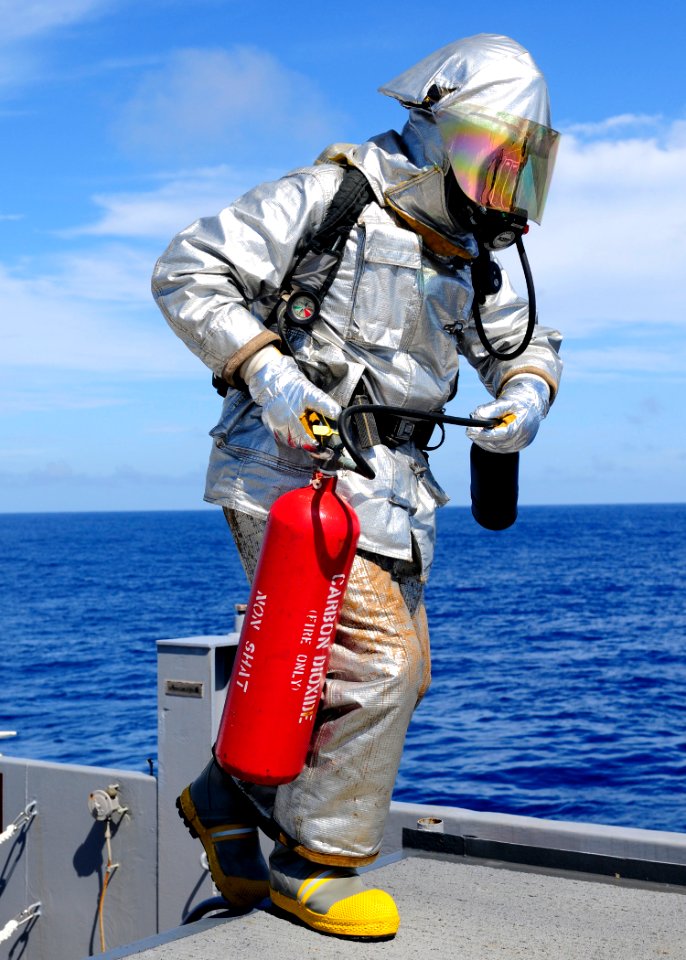 US Navy 110927-N-WJ771-100 Aviation Support Equipment Technician 2nd Class Joshua B. Cary carries a CO2 fire extinguisher onto the flight deck of U