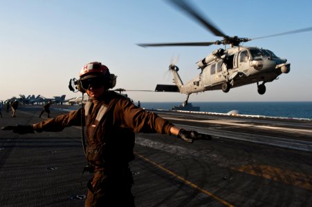 US Navy 110927-N-BT887-053 Aviation Machinist's Mate Airman Jesse Garman checks for a clear deck as an MH-60S Sea Hawk helicopter from Helicopter S