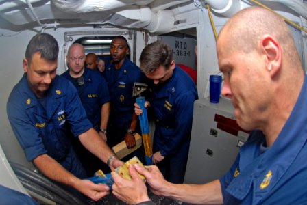 US Navy 110928-N-DU438-024 Sailors extend a metal shoring to set in place during a flooding drill aboard the guided-missile cruiser USS Gettysburg