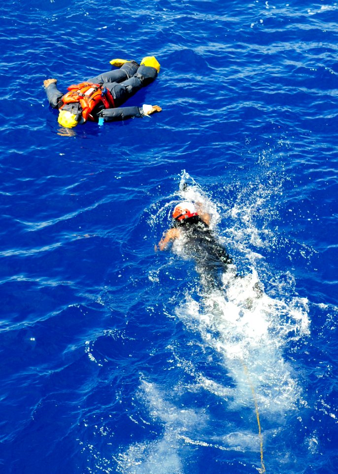 US Navy 110927-N-WJ771-091 Electronics Technician 3rd Class Jonathan A. Simmons swims toward a training dummy during a man overboard drill