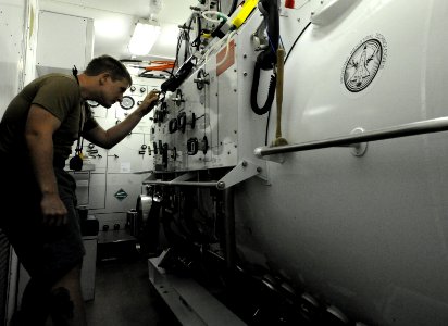 US Navy 110928-N-BA263-005 Navy Diver 2nd Class Jason Sargeant conducts pre-drill checks on a recompression chamber before members of Commander, Ta