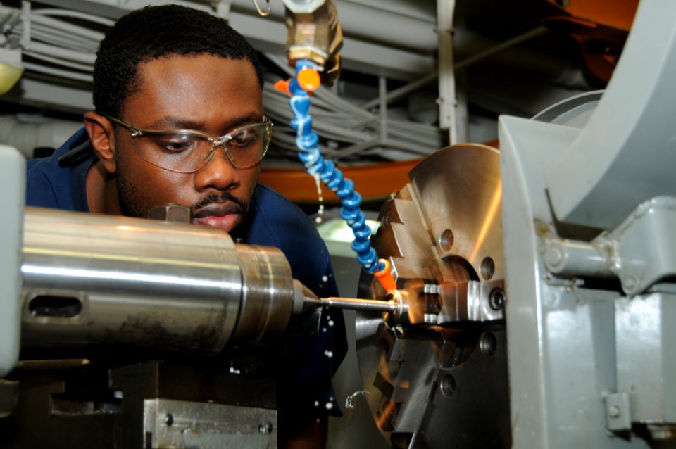 US Navy 110926-N-TU894-002 Machinery Repairman Fireman Mario C. Smith makes studs for distilling units in the machine shop aboard USS George H.W. B