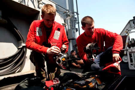 US Navy 110928-N-BT887-092 Aviation Boatswain's Mate (Handling) Airmen Brandon Gunn and Tyler Wadley prep firefighting gear aboard the Nimitz-class