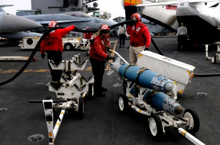US Navy 110927-N-GZ277-115 Aviation ordnancemen assigned to Strike Fighter Squadron (VFA) 81 move ordnance on the flight deck aboard the Nimitz-cla