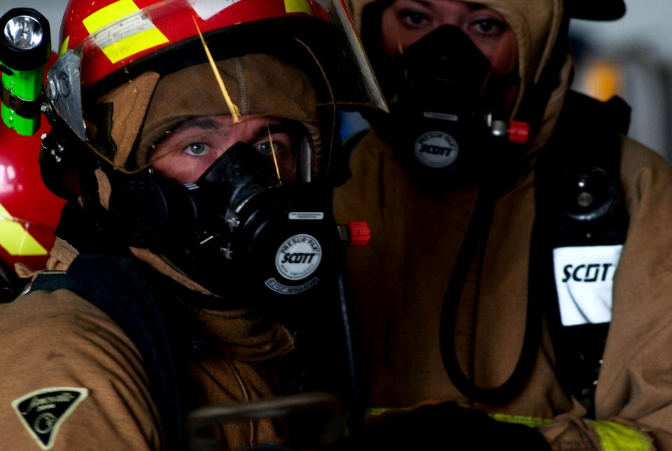 US Navy 110927-N-JN664-013 Damage Controlman 3rd Class Robert Gamble mans a hose during a simulated aircraft fire drill in the hanger bay aboard th